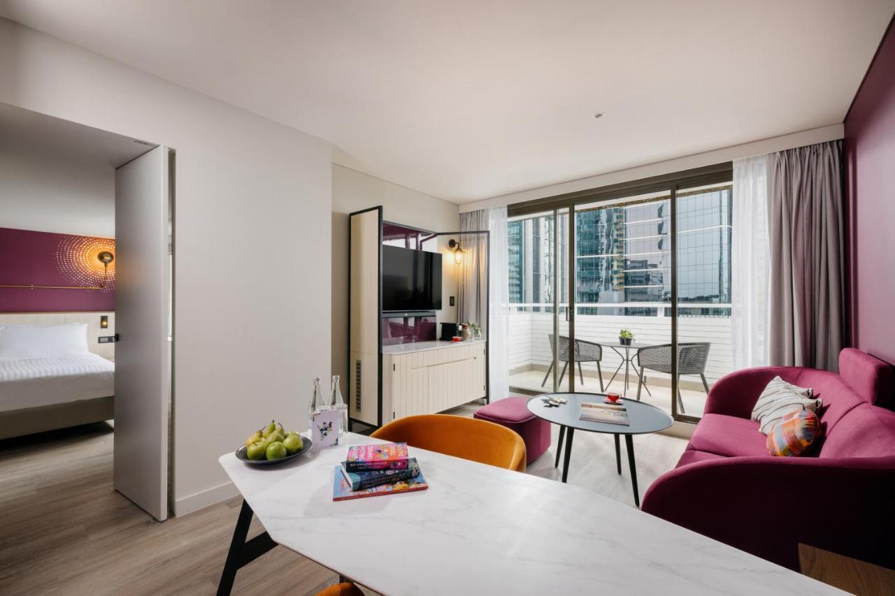 Suite de 1 dormitorio con balcón y vistas a la ciudad.