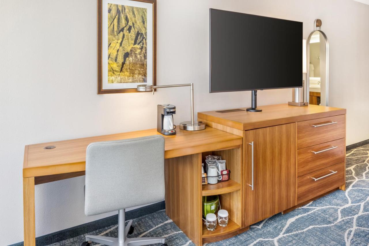 Habitación adaptada para personas con discapacidad, con cama extragrande, bañera, sofá cama y vistas a la ciudad