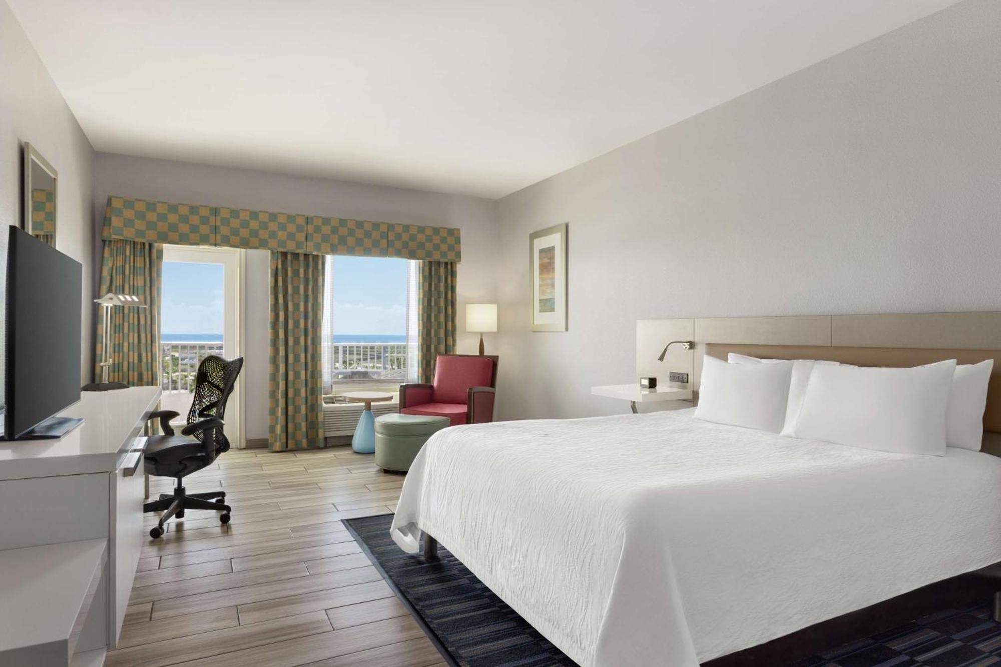 Habitación con cama extragrande y vistas parciales al mar