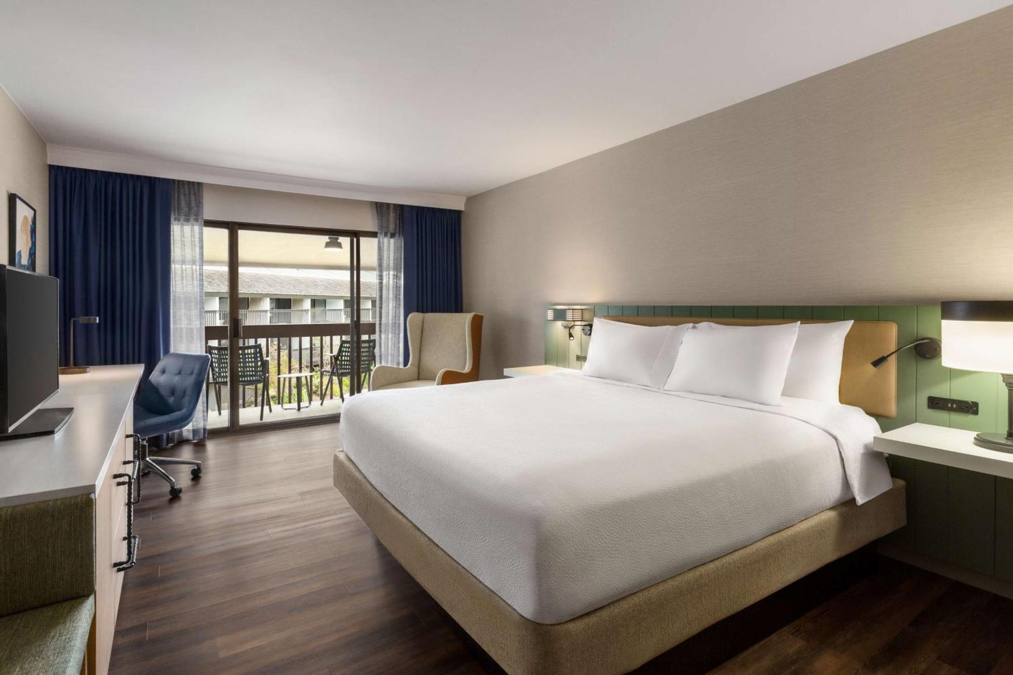 Habitación con cama extragrande, vistas a la piscina y balcón