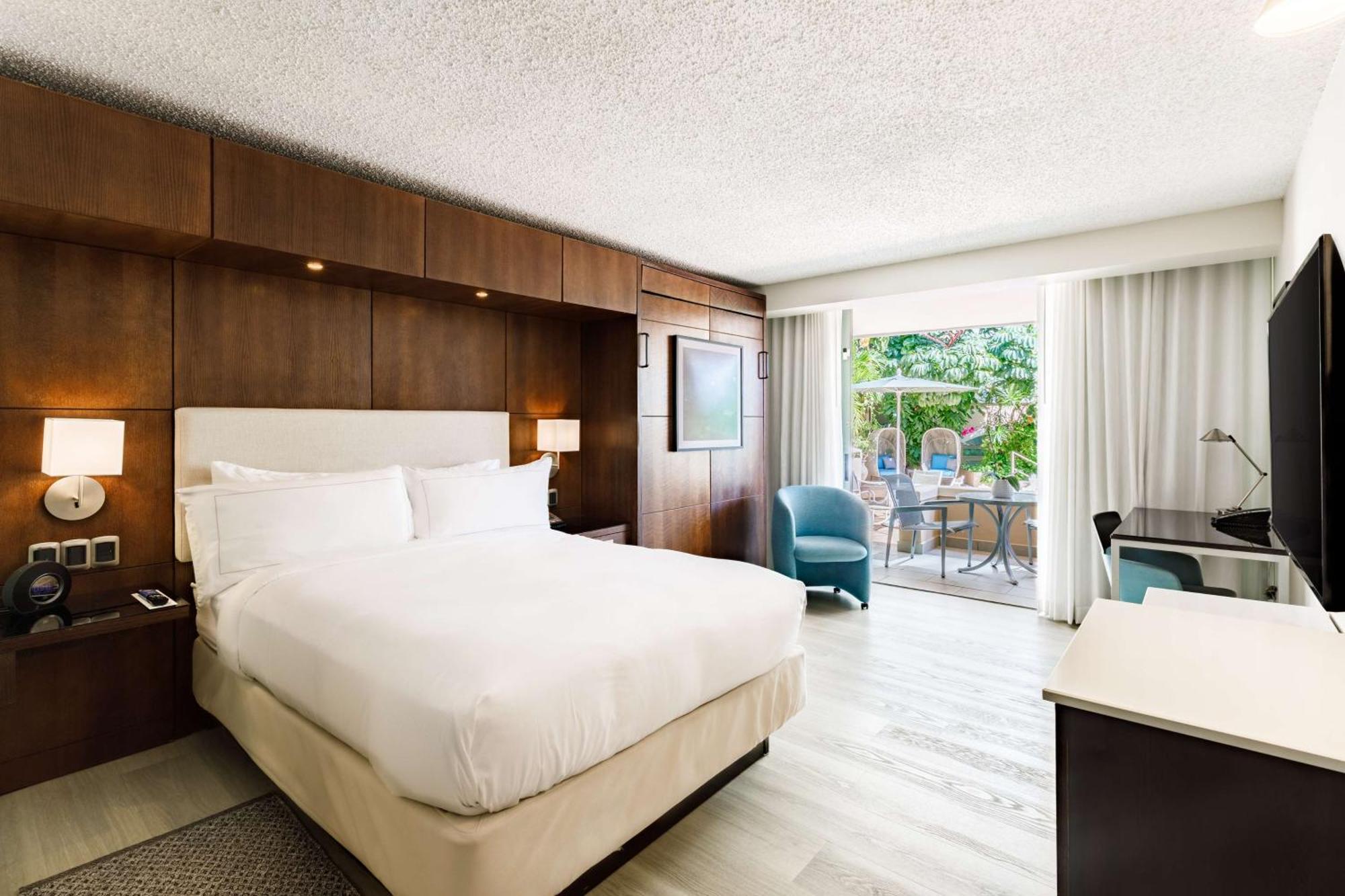 Habitación con cama grande, cama doble supletoria, balcón y vistas al jardín