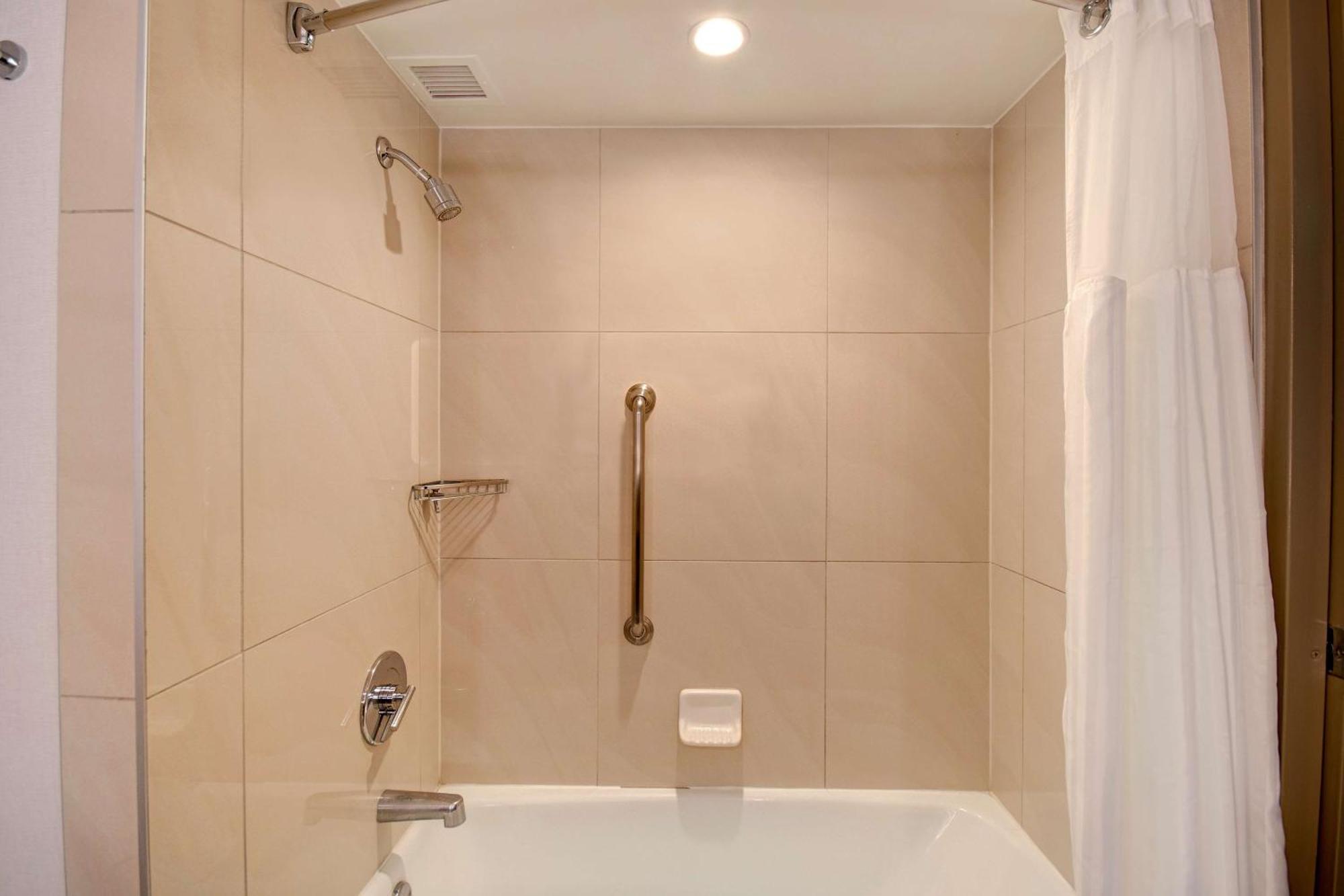 Habitación con cama extragrande y bañera adaptada para personas con movilidad reducida