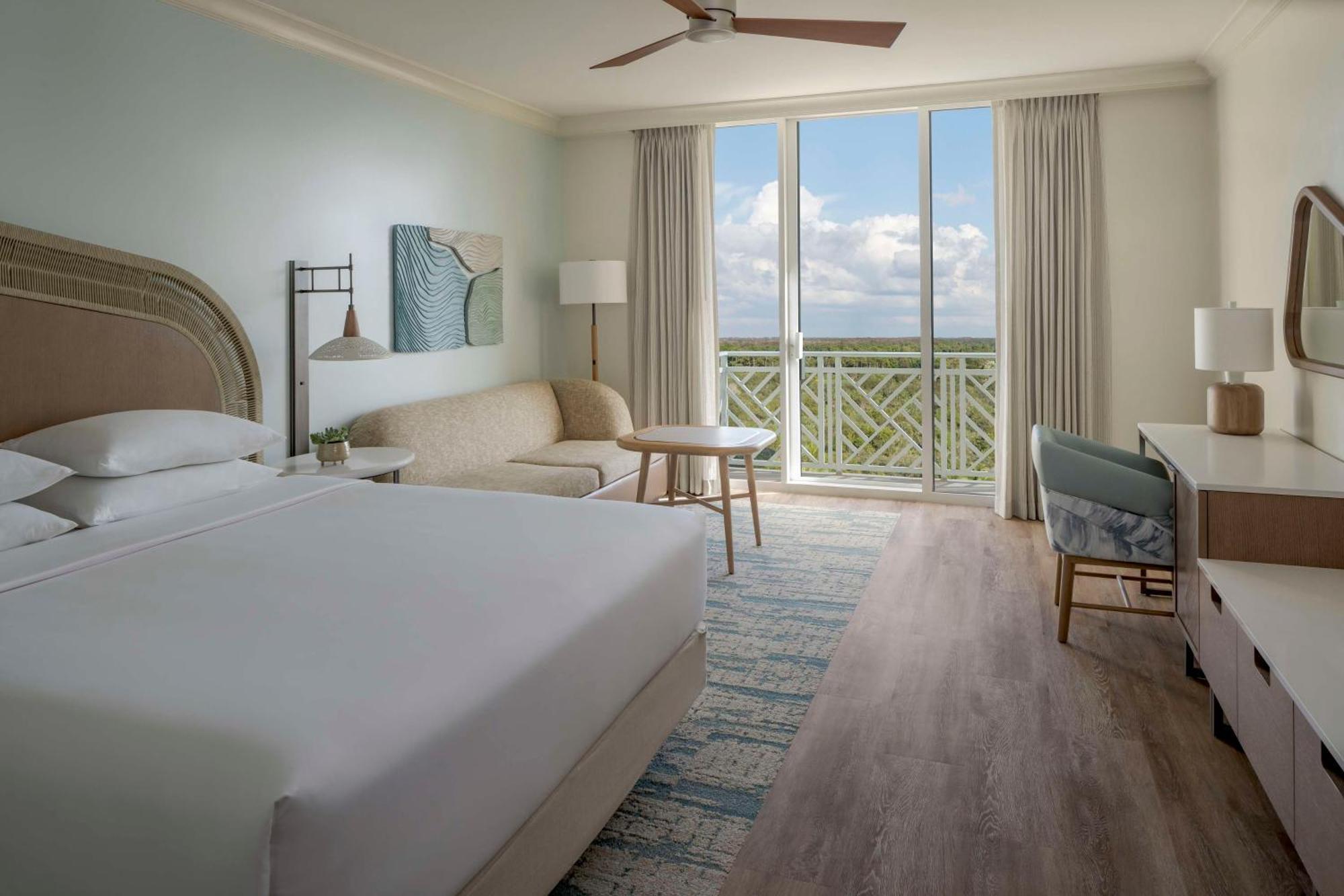 Habitación con cama extragrande, sofá cama y vistas parciales a la bahía