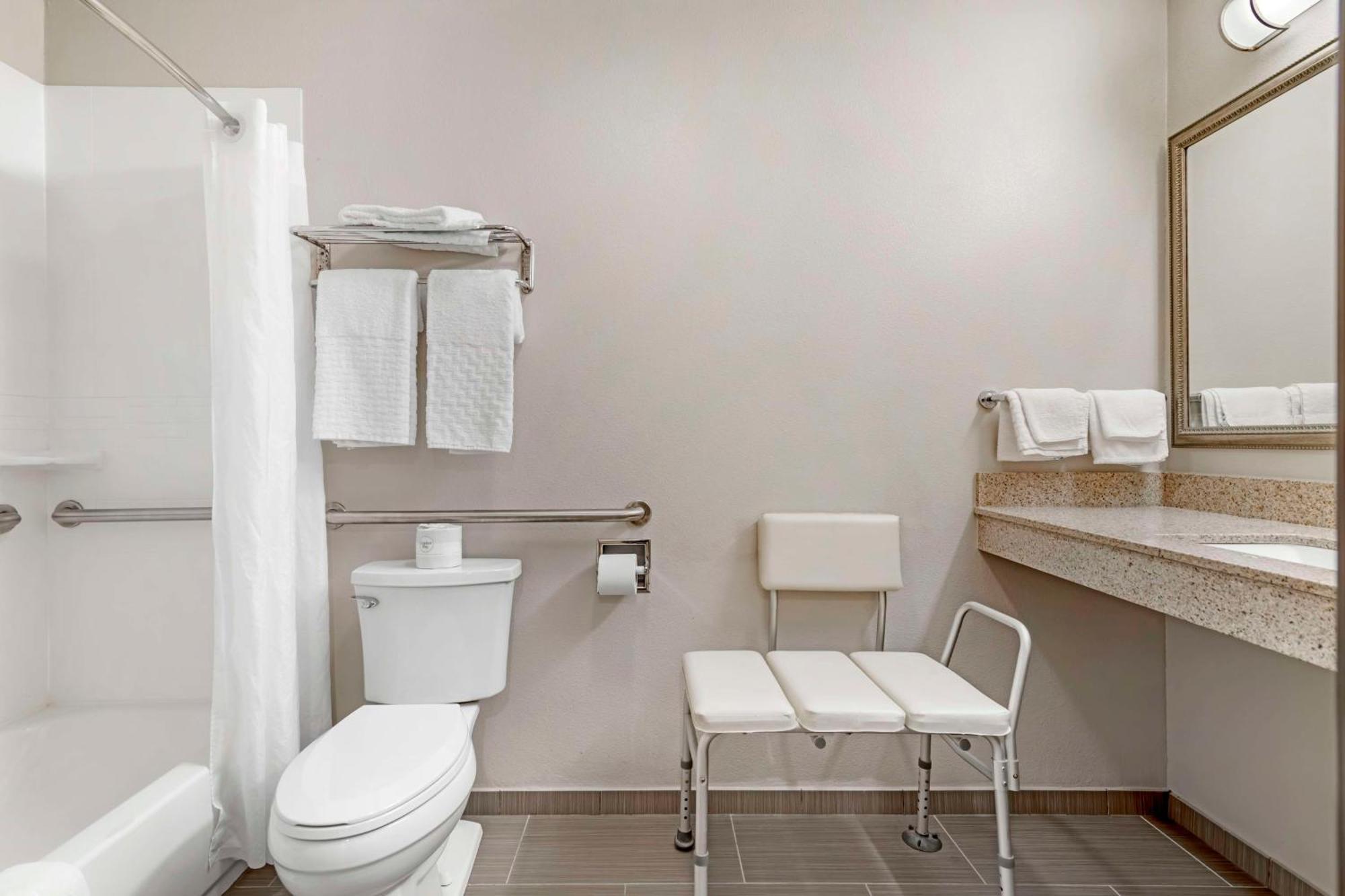 Habitación con cama grande y bañera adaptada para personas de movilidad reducida