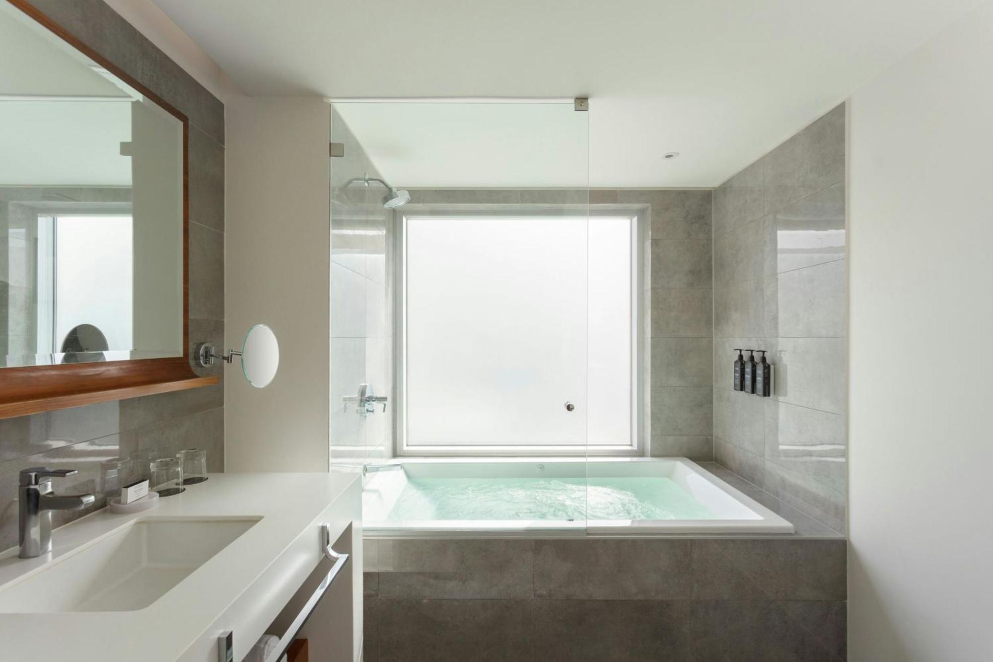 Habitación panorámica esquinera con cama extragrande y vistas a la ciudad