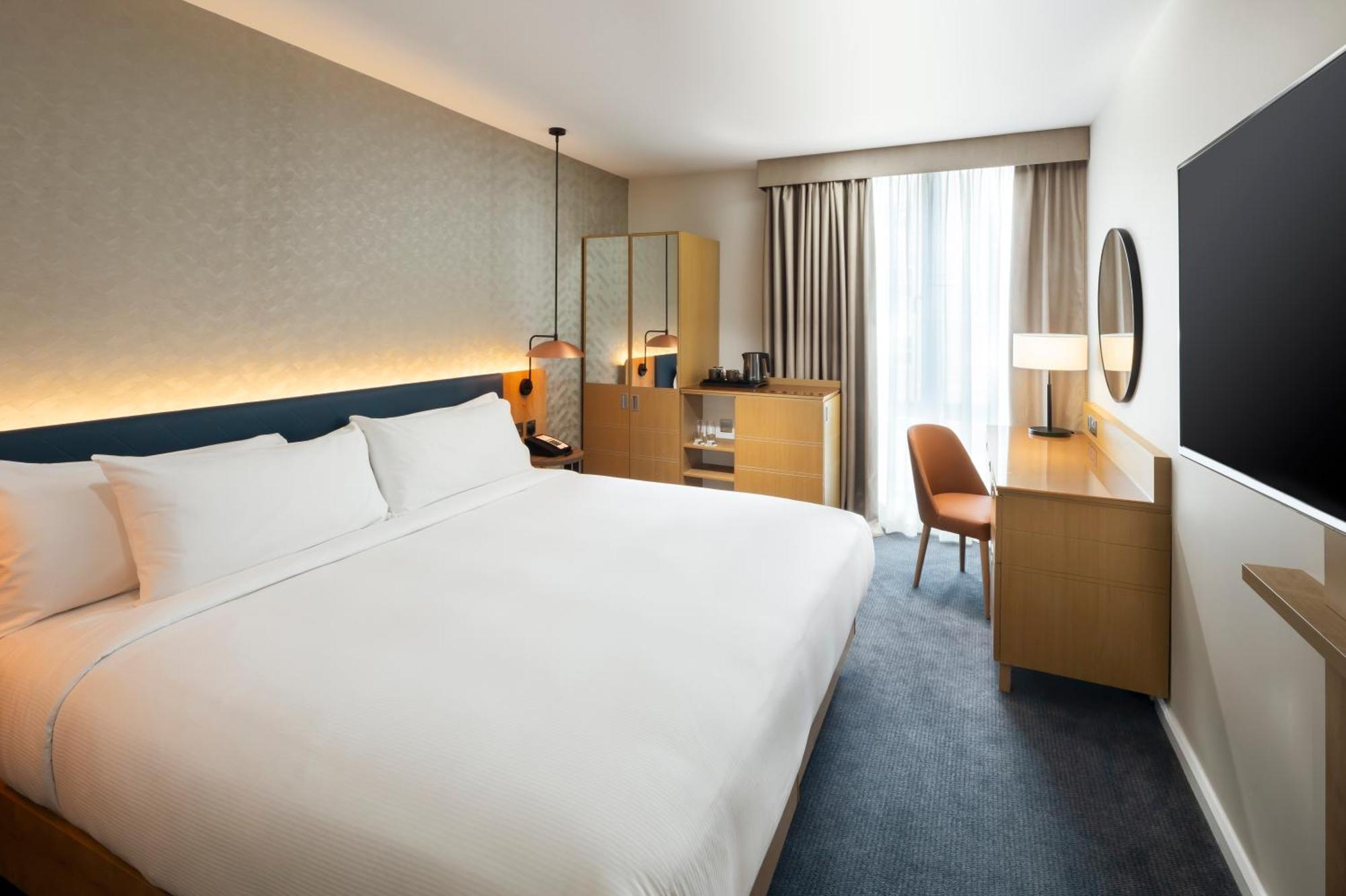 Habitación con cama grande y vistas al río, adaptada para personas de movilidad reducida