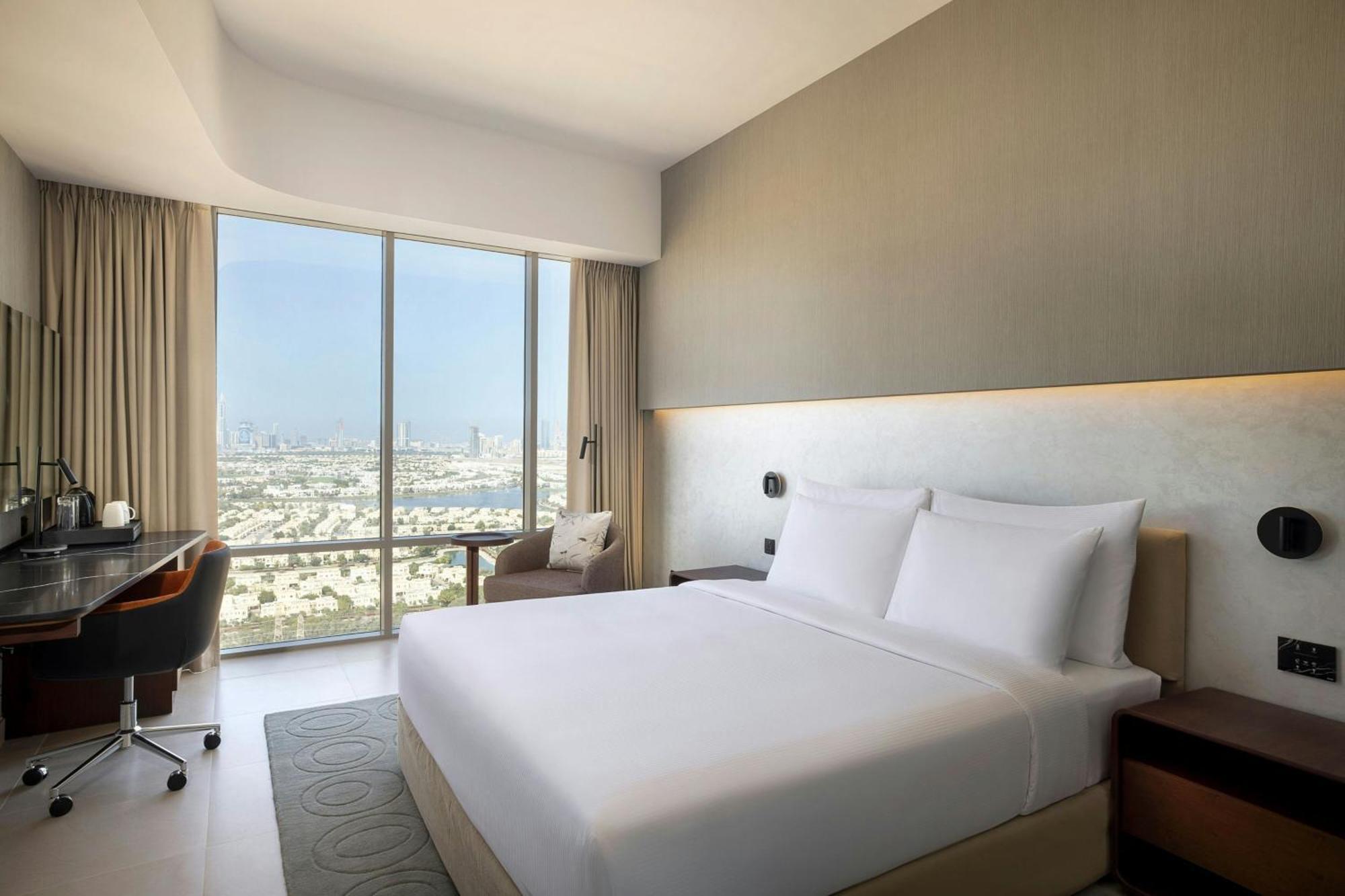 Deluxe Zimmer mit Kingsize-Bett und Blick auf die Skyline